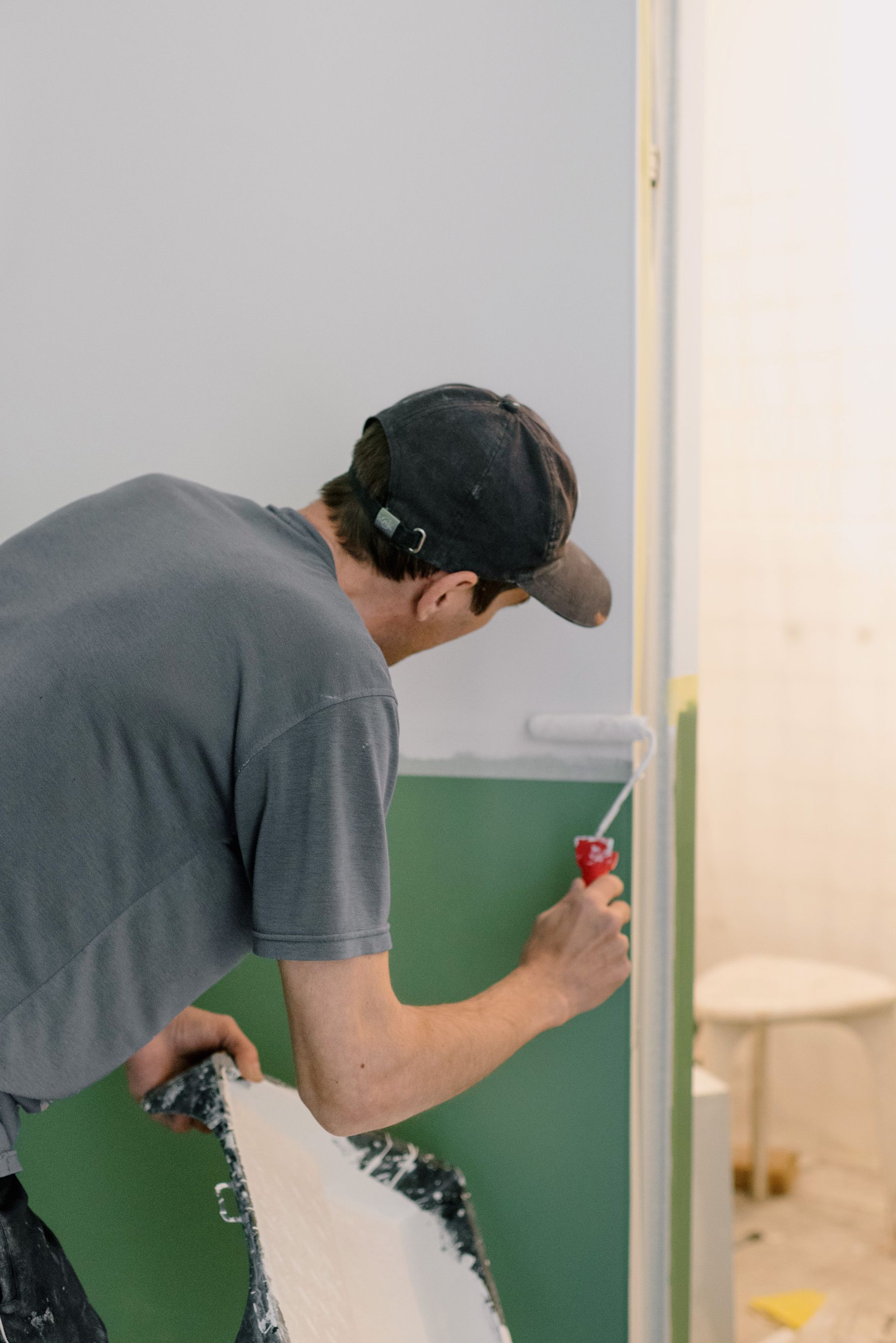 Painter rolling a wall in a bright room